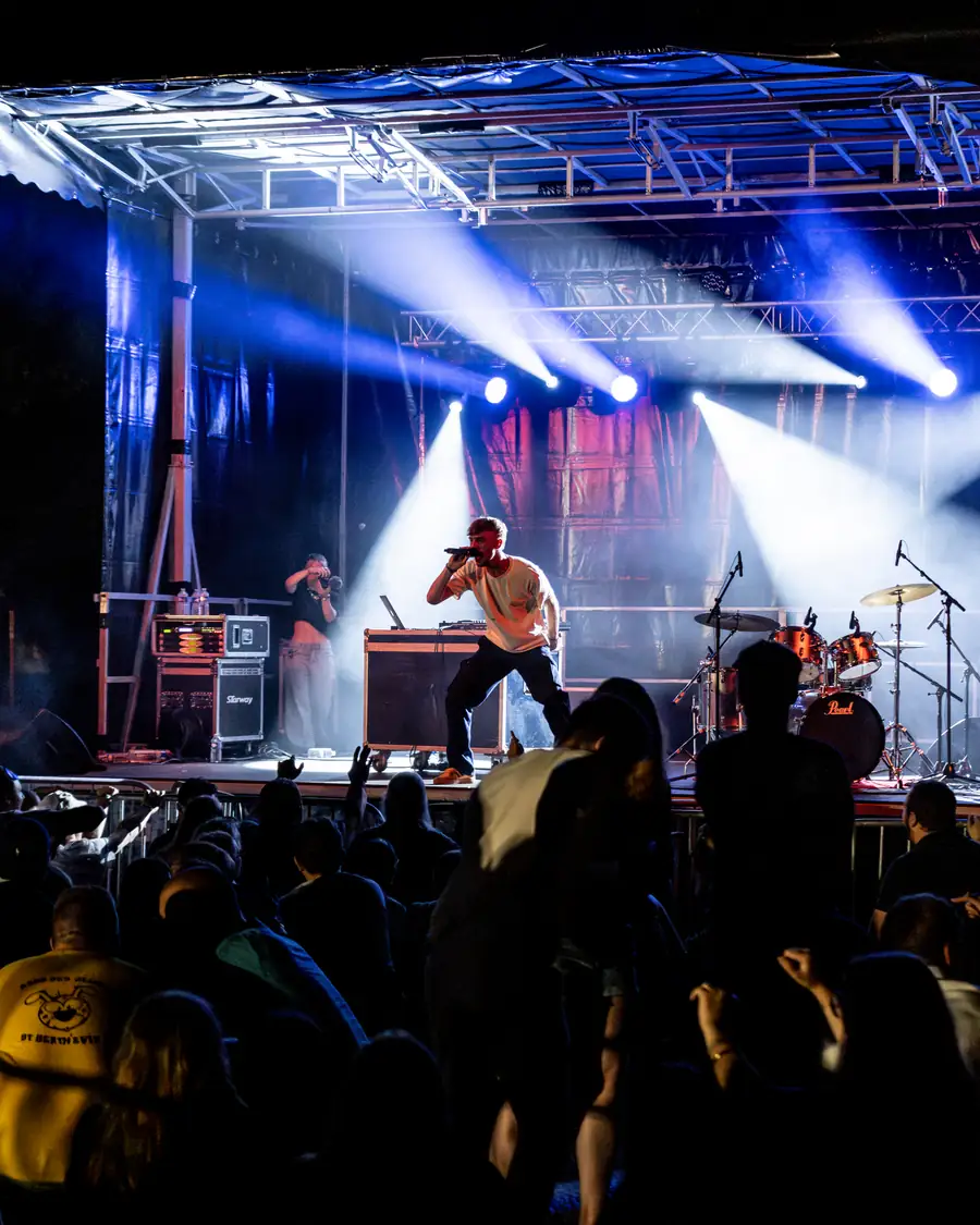 Scène de festival sous les lumières, vue depuis le public